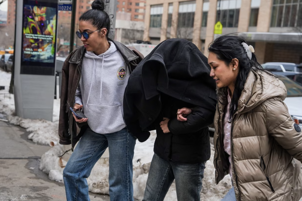Columbia University neuroscience student Ellie Aghayeva is escorted to her apartment with her face covered, after being detained by immigration agents. Photograph: Ryan Murphy/Getty Images